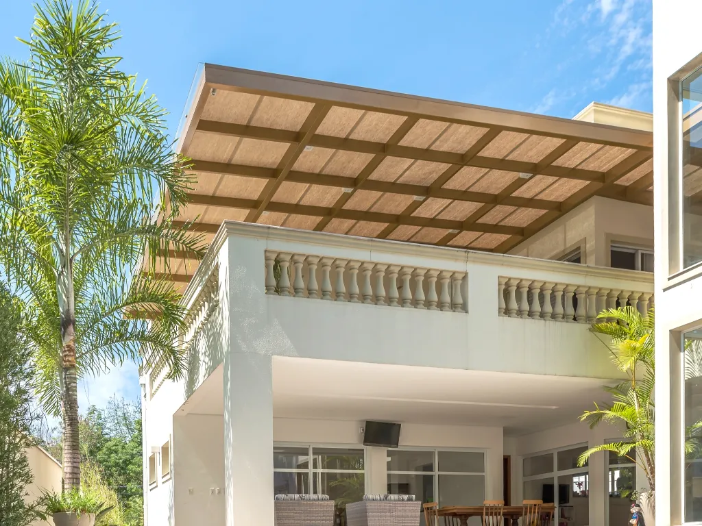 Casa com varanda de pergolado de ferro Cobrire e forro de bambu