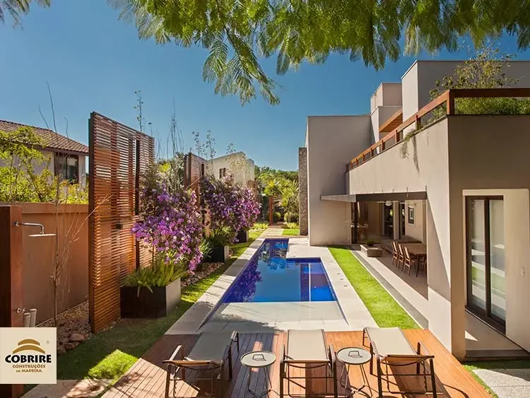 Piscina com Painel Ripado, Lounge e Área de Relaxamento em Residência Moderna: Cobrire